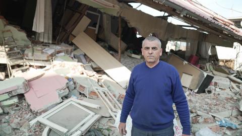 A father rummages through quake rubble to find his daughters’ memories