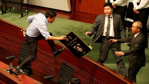 Hong Kong legislative session adjourned amid protests and heckling