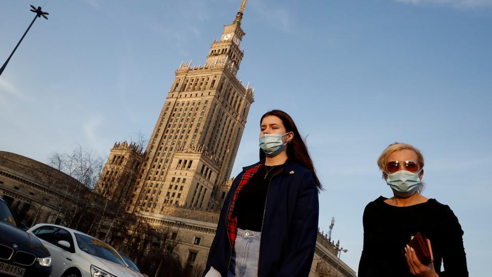 People walk in front of the Palace of Culture and Science in the centre of Warsaw, Poland on February 24, 2021.