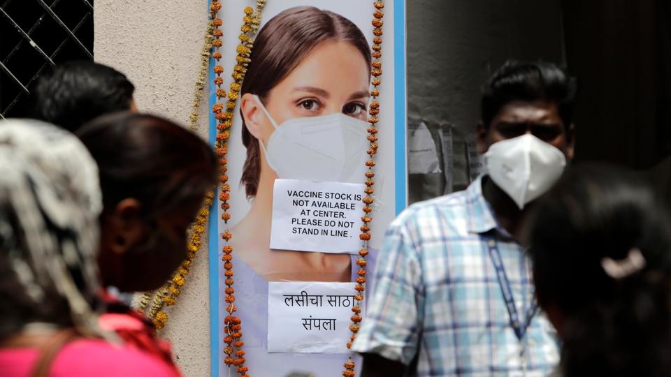 People wait outside a vaccination centre which has been closed because of a shortage of the Covid-19 vaccines in Mumbai, India, Friday, April 9, 2021.