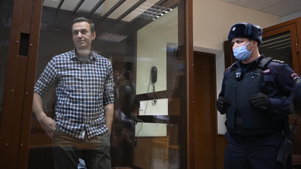 In this file photo taken on February 20, 2021, Russian opposition leader Alexey Navalny stands inside a glass cell during a court hearing at the Babushkinsky district court in Moscow.