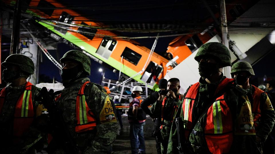 Rescuers work at a site where an overpass for a metro partially collapsed with train cars on it at Olivos station in Mexico City, Mexico, on May 4, 2021