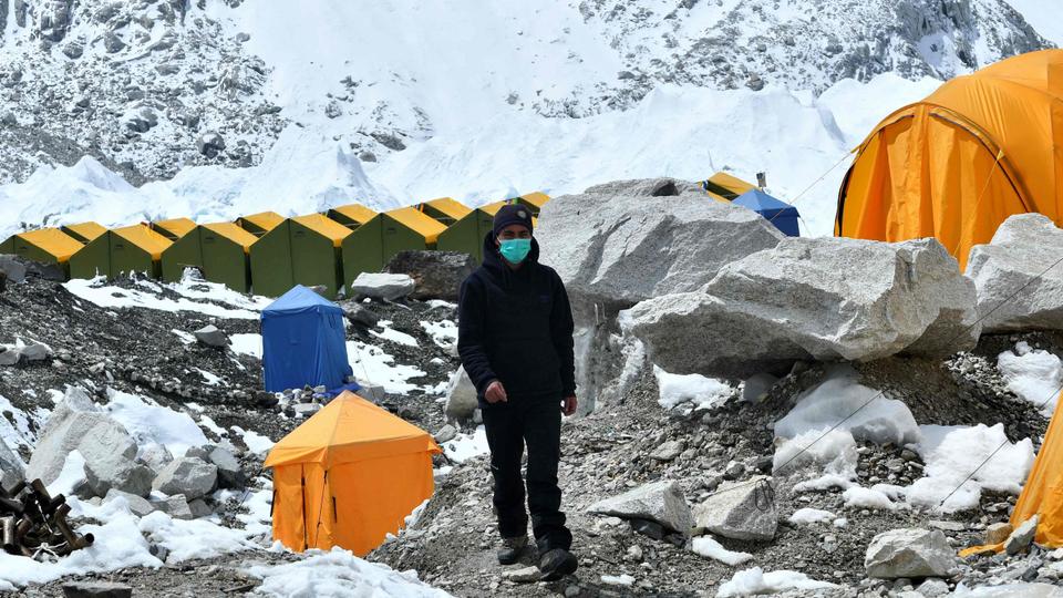 In this picture taken on May 1, 2021 an expedition base camp staff wearing a facemask walks around Everest base camp, some 140 Km northeast of Kathmandu.