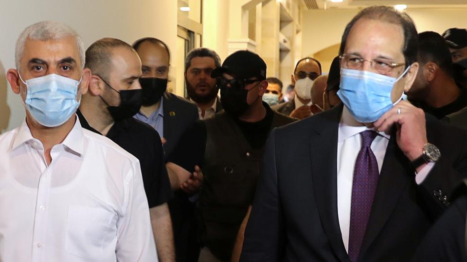 Hamas Gaza Chief Yehya al Sinwar and head of the Egyptian general intelligence Abbas Kamel walk as they meet in Gaza, May 31, 2021.