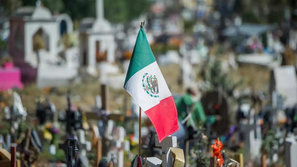 A Mexican flag is seen on a grave at the Municipal Pantheon in Valle de Chalco, Mexico state, Mexico, on November 19, 2020. amid the COVID-19 coronavirus pandemic.