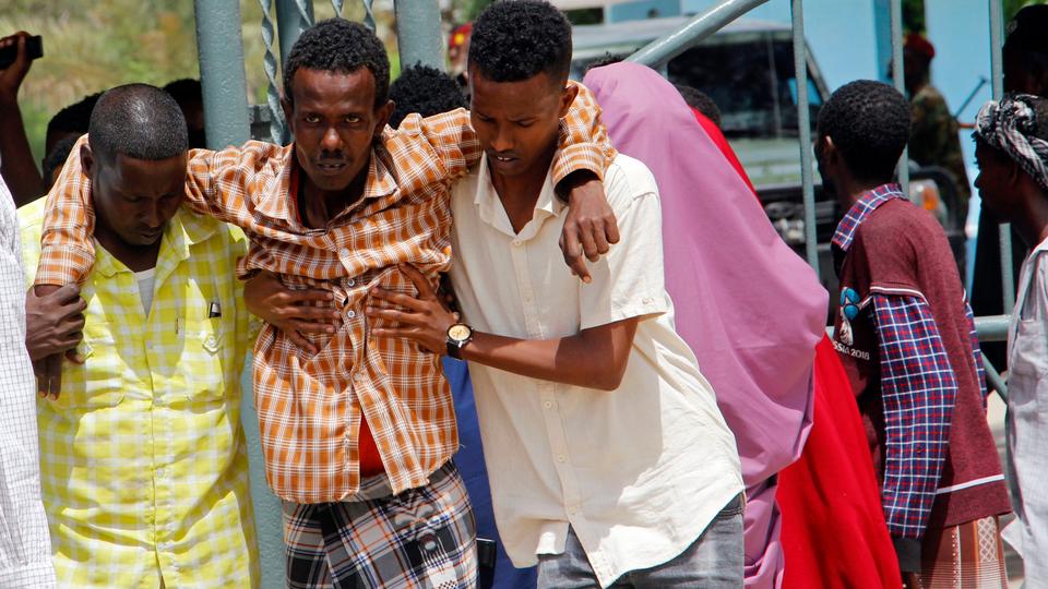 In this file photo, Somalis help a civilian who was wounded in suicide bomb attack at a military base in Mogadishu on June 15, 2021.