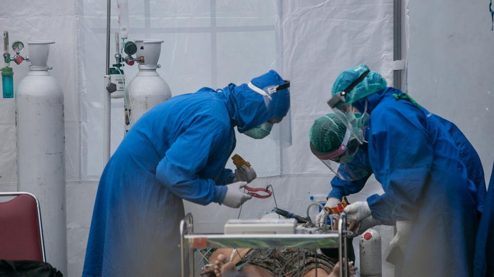 Healthcare workers treat a patient suffering from Covid-19 in an emergency tent in Sleman, Yogyakarta province, Indonesia, July 4, 2021