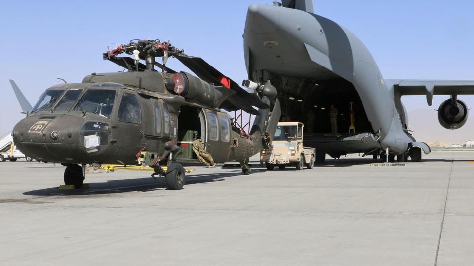 Aerial porters work with maintainers to load a UH-60L Blackhawk helicopter into a US Air Force C-17 Globemaster III during the withdrawal of American forces in Afghanistan, June 16, 2021.