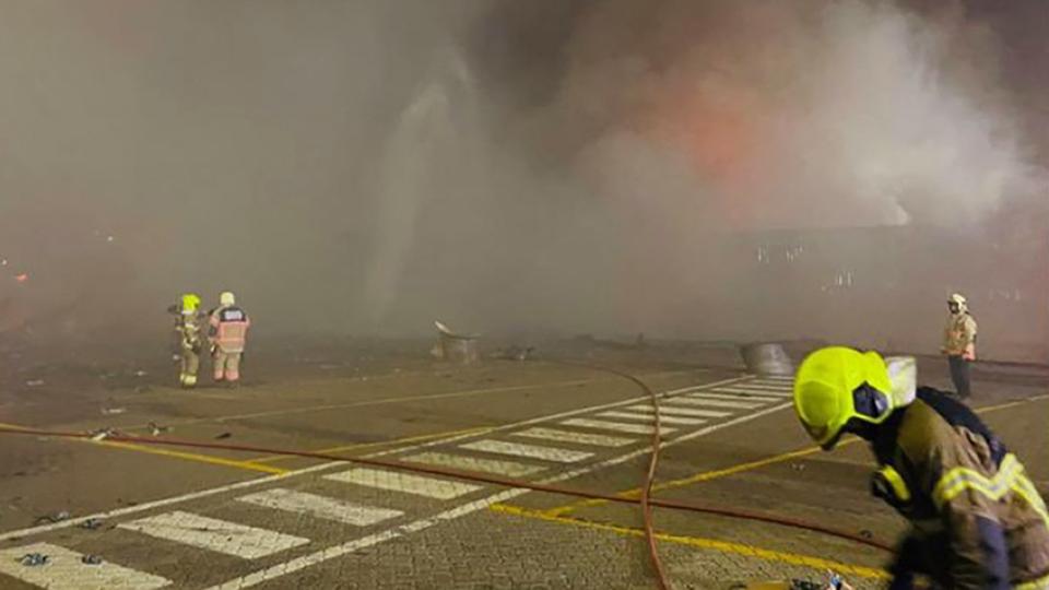 Cette photo fournie par le bureau des médias du gouvernement de Dubaï le 8 juillet 2021 montre des pompiers de la défense civile sur les lieux d'un incendie qui a éclaté dans le principal port de Dubaï, Jebel Ali, à la suite d'une explosion.