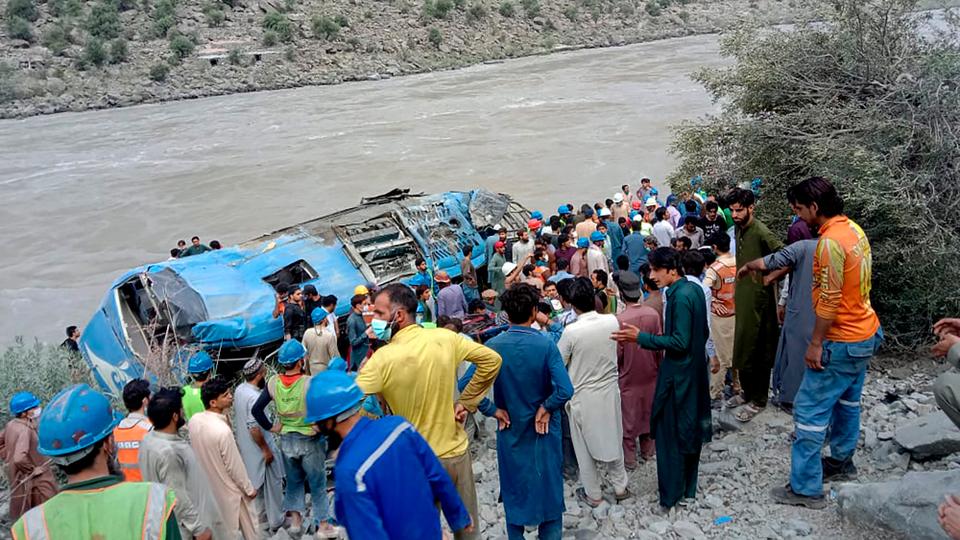 Local residents and rescue workers gather at the site of bus accident, in Kohistan Kohistan district of Pakistan's Khyber Pakhtunkhwa province, Wednesday, July 14, 2021.