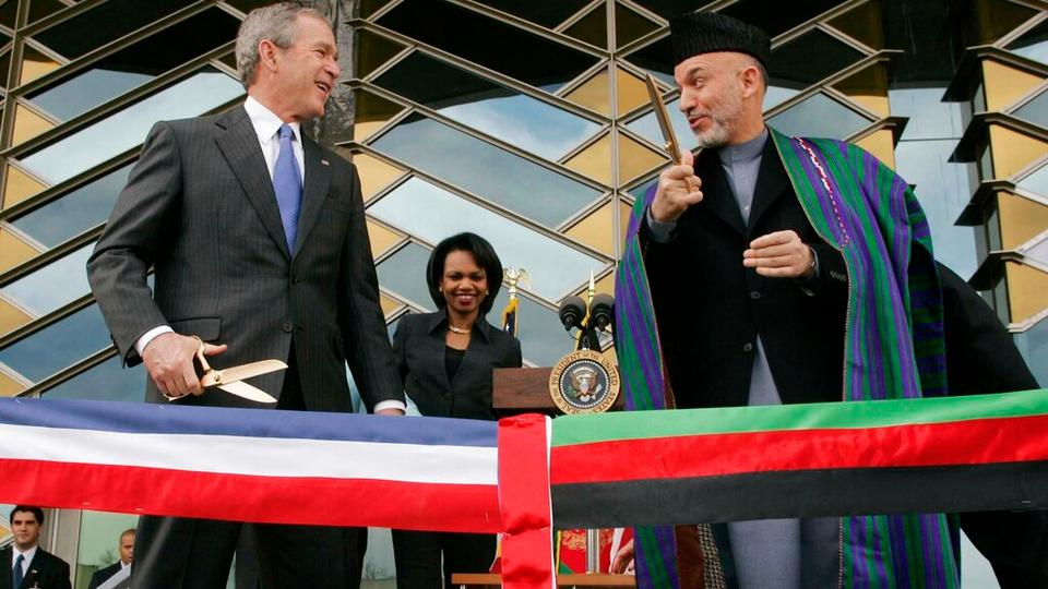 In this March 1, 2006 file photo, US President George W. Bush, left and Afghan President Hamid Karzai get ready to cut a ribbon to officially open the US Embassy in Kabul, Afghanistan.