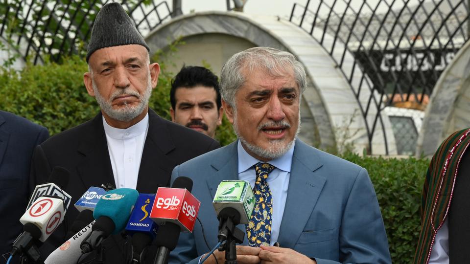 Chairman of the High Council for National Reconciliation Abdullah Abdullah (C) speaks next to former Afghan President Hamid Karzai (L) during a press conference at Hamid Karzai International Airport in Kabul on July 16, 2021.