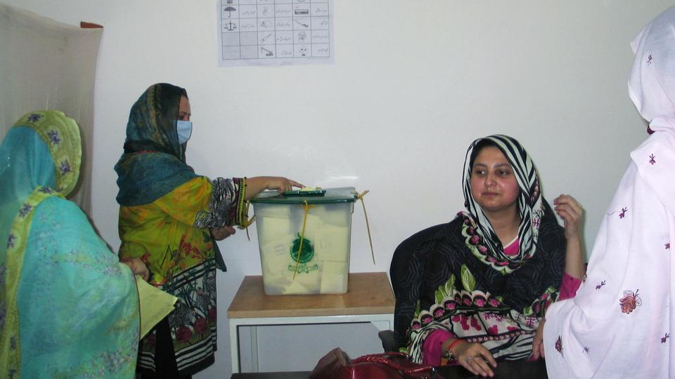 A woman casts her ballot at a polling station during voting to elect lawmakers for legislative assembly in Pakistan-administered Kashmir, in Muzafarabad, Pakistan, July 25, 2021.