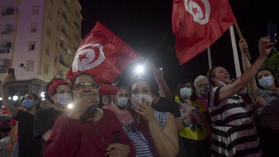 People celebrate in the street after Tunisian President Kais Saied announced the dissolution of parliament and Prime Minister Hichem Mechichi's government in Tunis on July 25, 2021.