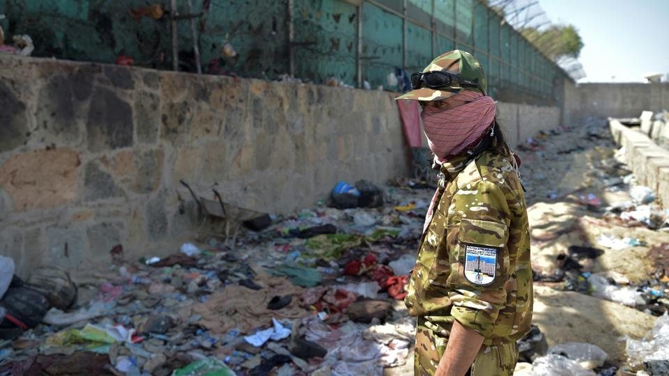 A Taliban fighter stands guard at the site of the August 26 twin suicide bombs, which killed scores of people including 13 US troops, at Kabul airport on August 27, 2021.