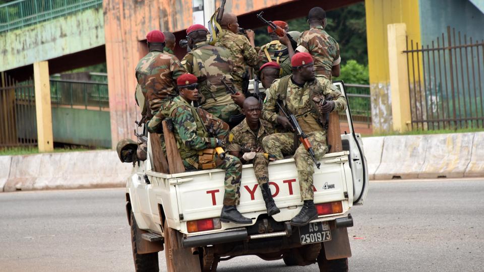 Gine silahlı kuvvetlerinin üyeleri, sürekli silah sesleri duyduktan sonra 5 Eylül 2021'de Conakry'deki merkezi Calum bölgesinden geçiyorlar.