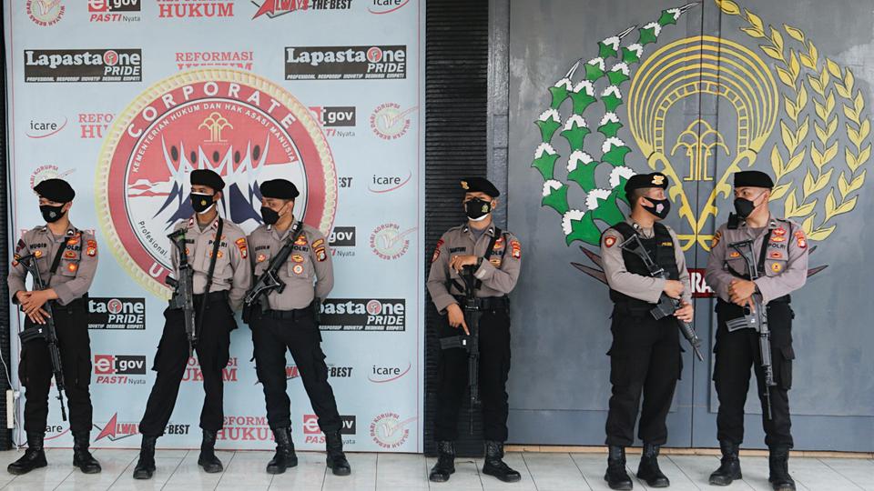 Police officers stand guard at the main entrance gate of Tangerang prison following a fire overnight at the overcrowded jail on the outskirts of Jakarta, Indonesia on September 8, 2021.