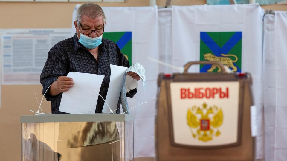 A man casts his ballots at the last day of a three-day long parliamentary elections in the far eastern city of Vladivostok, Russia, September 19, 2021.