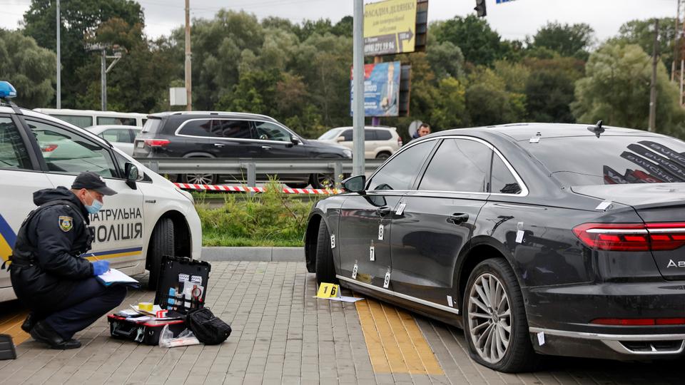 An investigator examines bullet holes in a car of Serhiy Shefir, President Zelenskyy's principal aide, following an assault outside the capital Keiv, Ukraine on September 22, 2021.