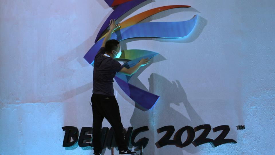 A man adjusts an emblem of the Beijing 2022 Winter Olympic Games before a ceremony unveiling the slogan, in Beijing, China on September 17, 2021.