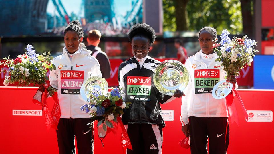 Kenya's Joyciline Jepkosgei celebrates with trophy at the podium winning the elite women's race with Ethiopia's Degitu Azimeraw second and Ethiopia's Ashete Bekere third in London, Britain, October 3, 2021.