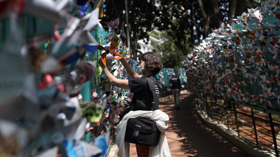 A woman puts a windmill in memory of the people who died due to the coronavirus disease in Sao Paulo, Brazil on October 6, 2021.