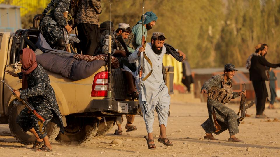 Taliban fighters get out of a vehicle as they take a day off to visit the amusement park at Kabul's Qargha reservoir, on the outskirts of Kabul, on October 8, 2021.