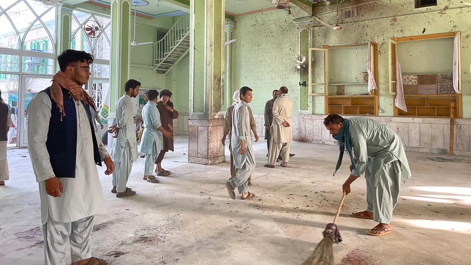 Afghan men inspect the damage inside a Shia mosque in Kandahar on October 15, 2021, after a suicide bomb attack during Friday prayers that killed at least 33 people and injured 74 others, Taliban officials said.