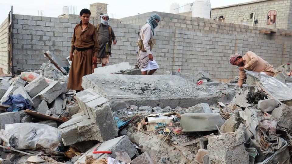 People browse through the rubble of a house destroyed by Houthi missile attack in Marib, Yemen on October 3, 2021.