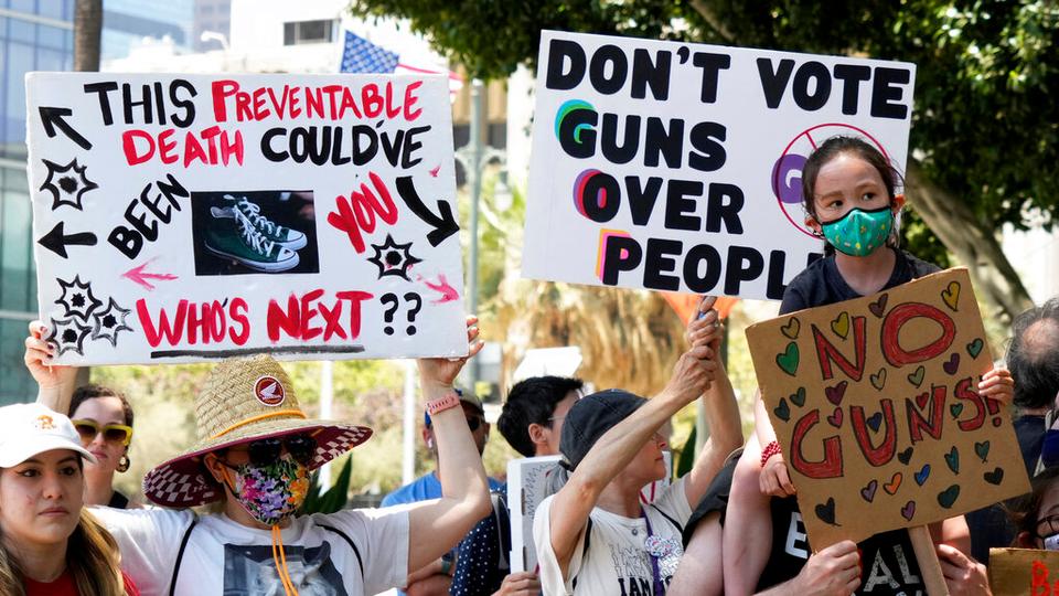 Protesters hold up signs during a gun control rally outside City Hall in Los Angeles on Saturday, June 11, 2022.