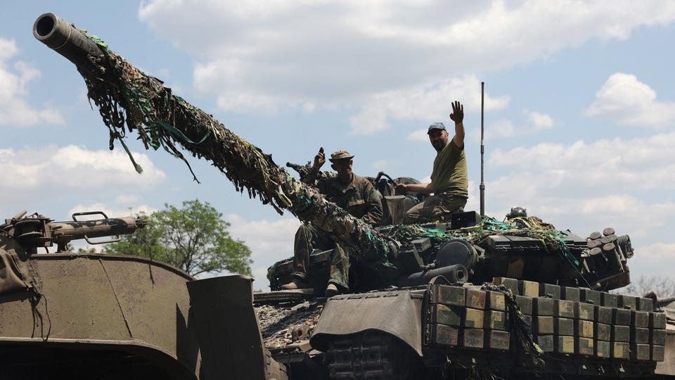 Ukrainian troop members stand on a tank on a road in the eastern Ukrainian region of Donbass on June 21, 2022.