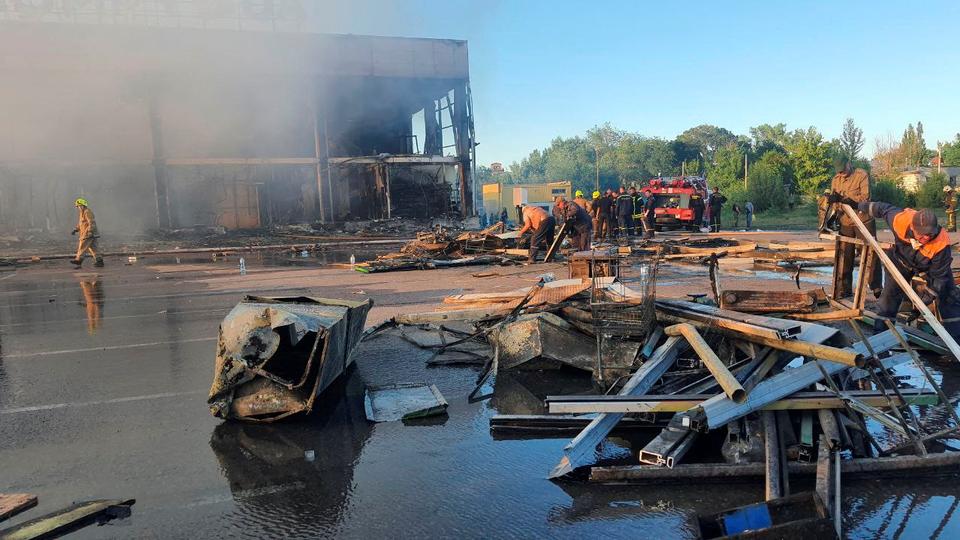 Rescuers work at a site of a shopping mall hit by missiles, in Kremenchuk, in Poltava region of Ukraine.