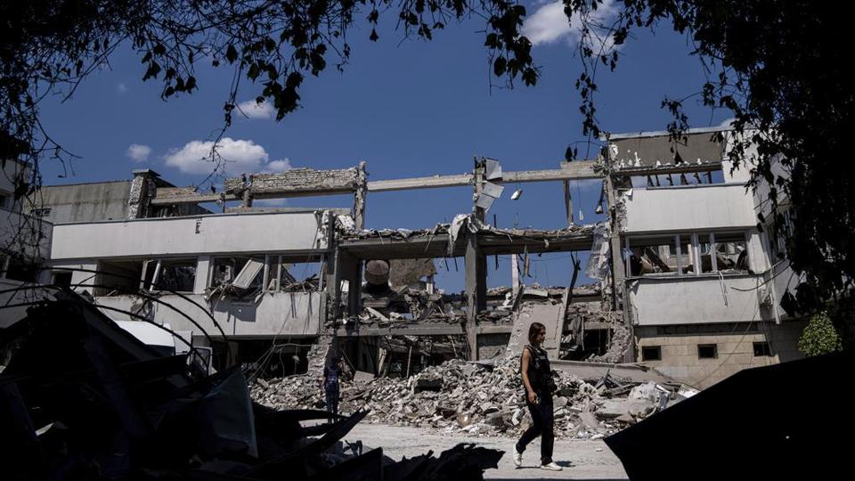 Ukrainian journalists walk in the yard of the National Pedagogic university allegedly destroyed by a Russian attack in Kharkiv, Ukraine.