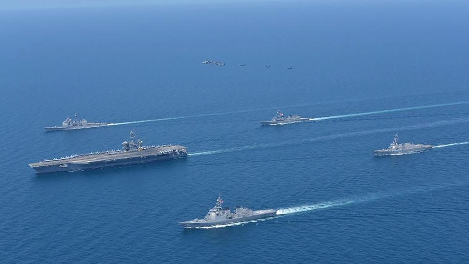 This photo provided by Japan Maritime Self-Defense Force shows USS Abraham Lincoln, left, and JS Kongo, front, sail in formation during a US-Japan bilateral exercise at the Sea of Japan on April 12, 2022.