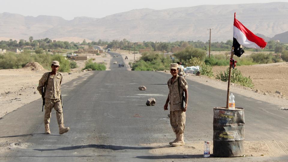 Yemeni soldiers stand guard as a Yemeni flag flies on a checkpoint outside Marib, Yemen October 15, 2015.