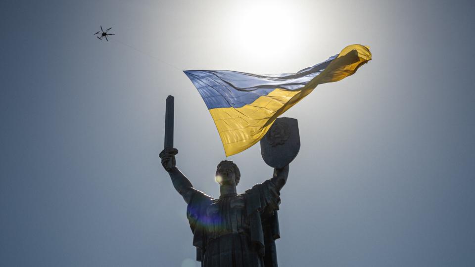 A drone flying with a giant Ukrainian national flag passes over the Motherland monument in Kiev during Ukraine's Independence Day.