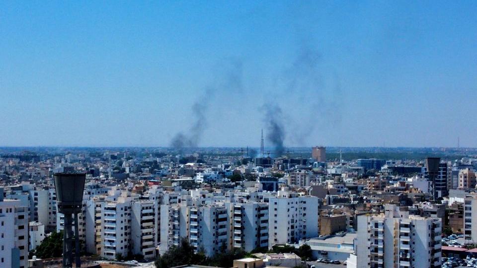 Small arms fire and explosions rocked several districts of Tripoli, with smoke rising from damaged buildings.