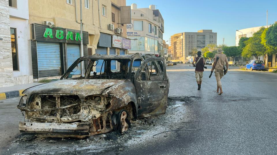 damaged vehicle is pictured in a street in the Libyan capital Tripoli on August 27, 2022, following clashes between rival Libyan groups.