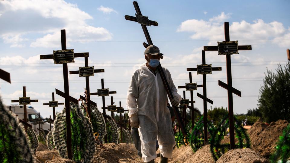 A volunteer places a cross with a number to a grave of one of unidentified people allegedly killed by Russia, during a mass burial ceremony in Kiev's Bucha town.