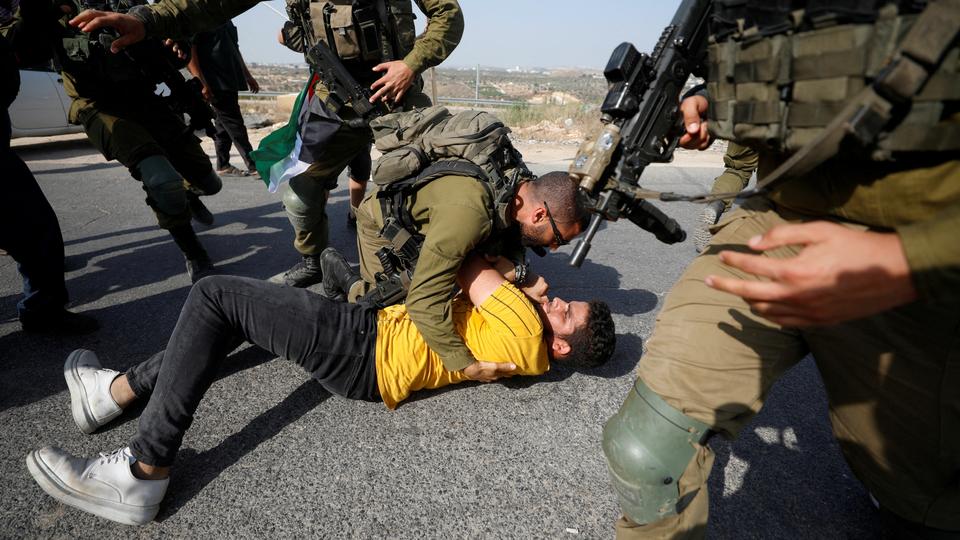 Israeli soldiers detain a Palestinian during a protest against illegal Israeli settlement activity, in Qalqilya in occupied West Bank.