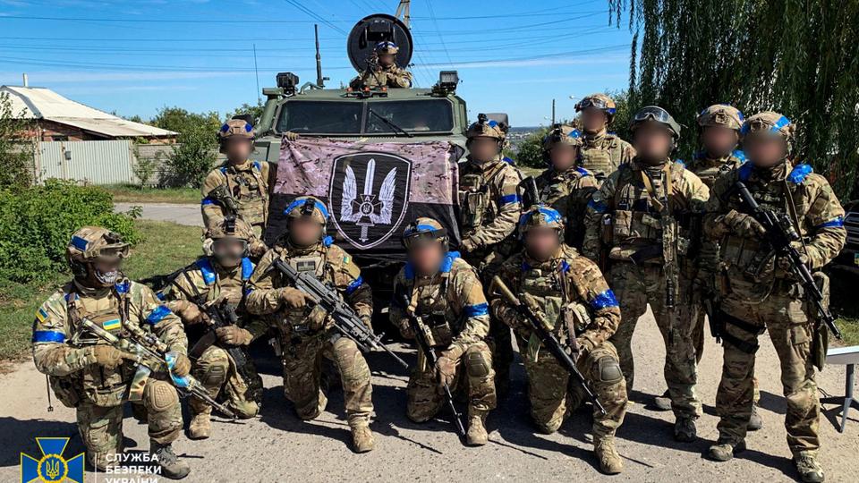 Ukrainian soldiers pose for a picture in the recently liberated town of Kupiansk in Kharkiv region.