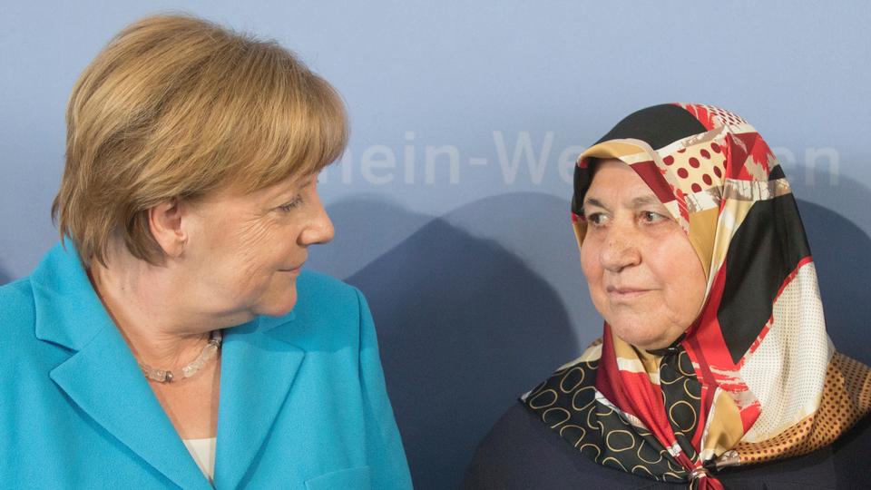 In this file photo, then-German chancellor Angela Merkel (L) talks to Mevlude Genc, mother, grandmother and aunt of the victims, in Duesseldorf, western Germany, Tuesday, May 29, 2018, during a commemoration of the 25th anniversary of a firebombing in which five Turks were killed in Solingen.