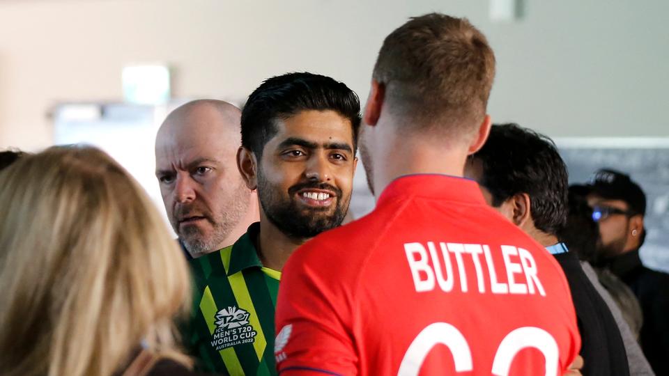Pakistan's Captain Babar Azam (L) shakes hands with England's Captain Jos Buttler after a press conference at Melbourne Cricket Ground, ahead of final match.