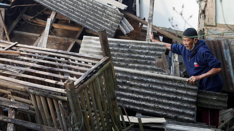An elderly man stands near his destroyed house, after an earthquake in West Java province, Indonesia, November 22, 2022.