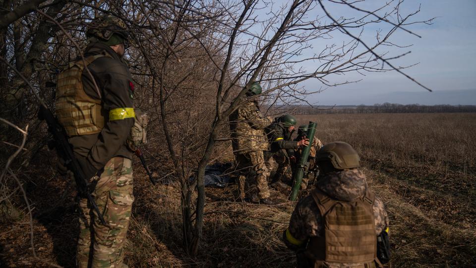 Ukrainian soldiers from the 68th brigade adjust a mortar launcher at a position along the front line in Donetsk region.