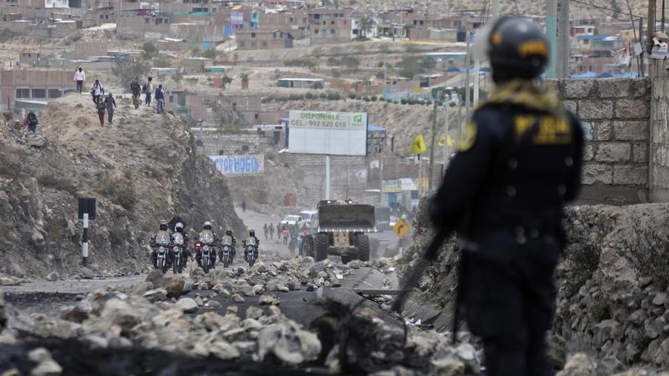 Police arrive to clear debris from a highway, placed by supporters of Pedro Castillo protesting his detention in Arequipa on December 15, 2022.