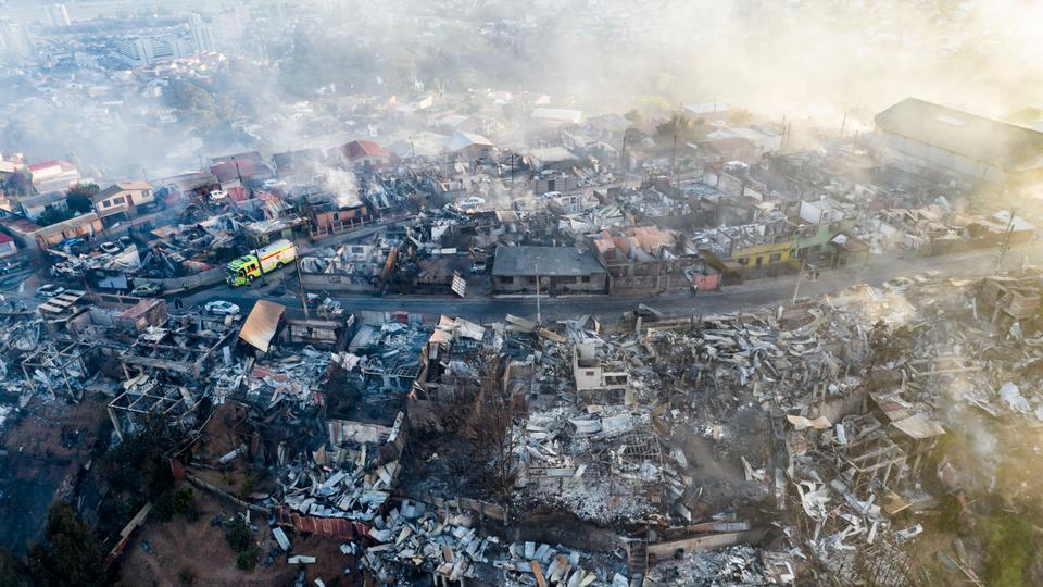 Residents inspect by the remains of destroyed homes after a wildfire in Vina del Mar, Chile on December 23, 2022.