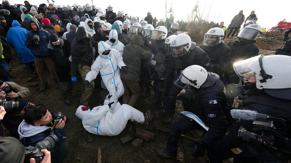 About 100 activists kept up efforts to try to block the way into the village.