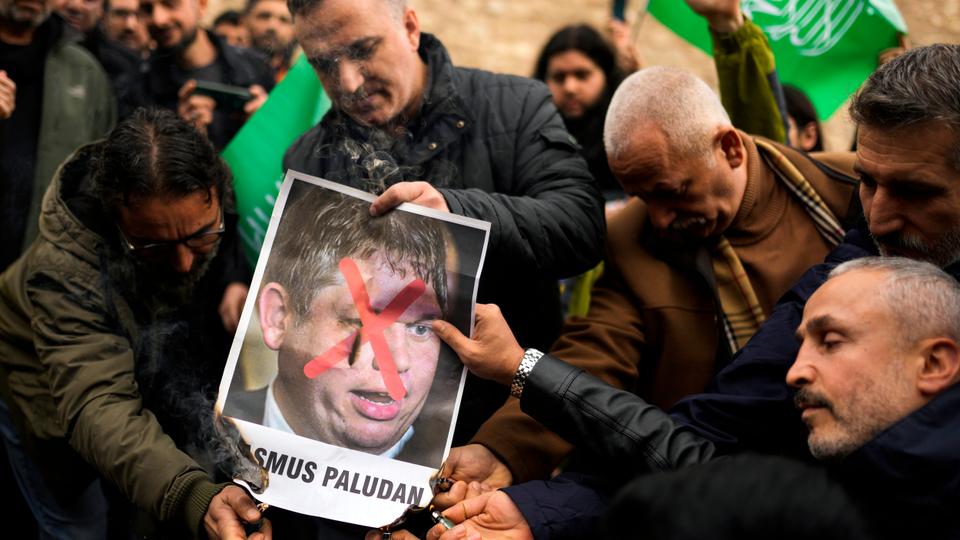 People set on fire a photograph of far-right activist Rasmus Paludan during a protest