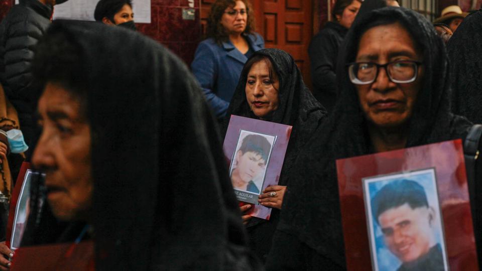 Residents carry photographs of victims during nationwide protests against President Boluarte, while walking through streets of Puno during a procession.